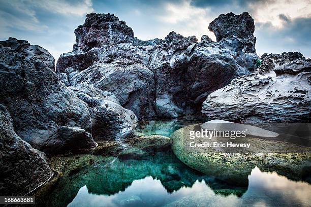 reflection at piranha rock at sunset, jeju island - jeju stock-fotos und bilder