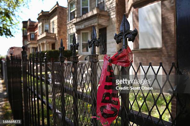 Crime scene tape hangs from a fence near the location where 21-year-old Ronald Baskin was shot and killed Sunday afternoon on May 13, 2013 in...
