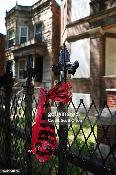 Crime scene tape hangs from a fence near the location where 21-year-old Ronald Baskin was shot and killed Sunday afternoon on May 13, 2013 in...