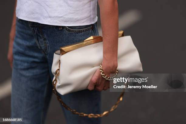 Fashion Show Guest was seen wearing a jeans, a strapless white top and a white jimmy choo bag with yellow gold bond and a golden bracelet before the...