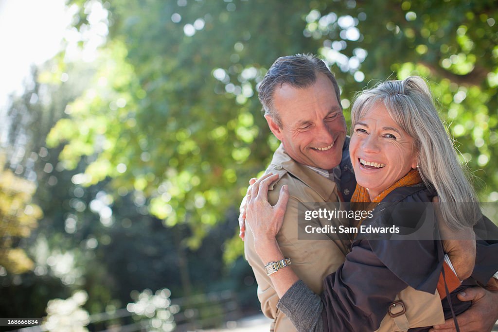 Portrait de souriant couple embrassant dans le parc ensoleillé