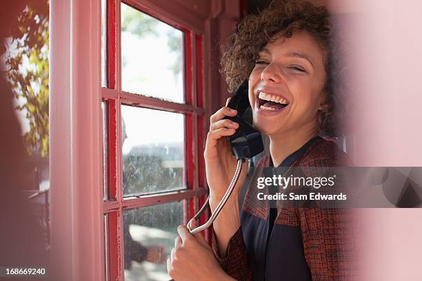 porträt eines lächelnden frau mit telefonzelle - telefonzelle stock-fotos und bilder