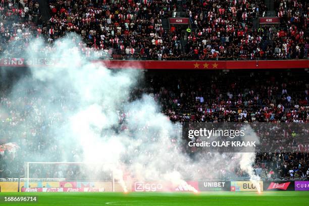 This photograph taken on September 24 shows smoke rising from fireworks thrown on the field by Ajax' supporters during the Dutch Eredivisie football...