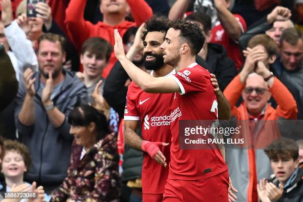 Liverpool's Portuguese striker Diogo Jota celebrates with Liverpool's Egyptian striker Mohamed Salah after scoring their third goal during the...
