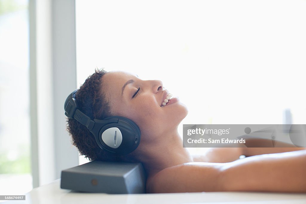Woman listening music in bathtub