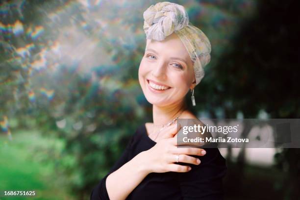 portrait of a smiling young girl suffering from cancer or baldness, in a headscarf close-up. pink october - lymphoma 個照片及圖片檔