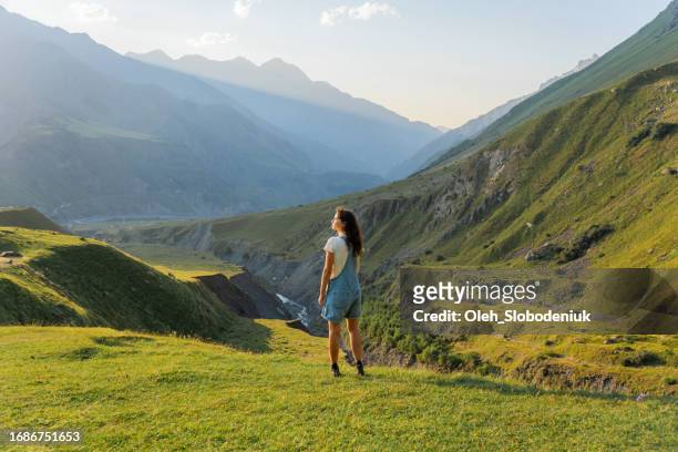 woman standing on the background of mountains at sunset - caucasus stock pictures, royalty-free photos & images