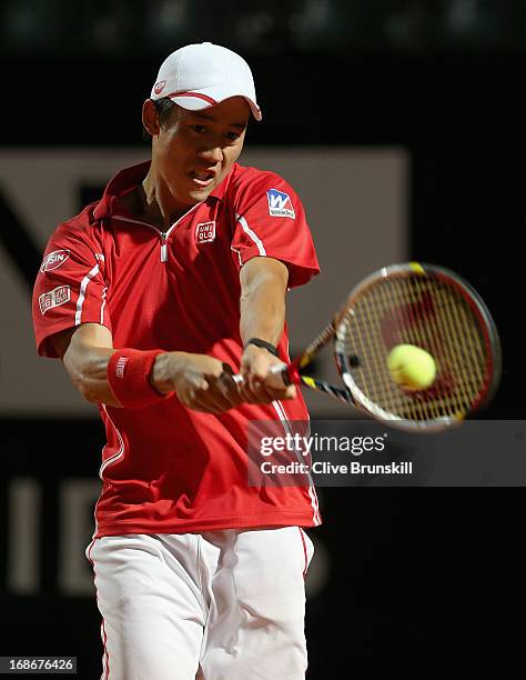 Kei Nishikori of Japan plays a backhand against Paolo Lorenzi of Italy in their first round match during day two of the Internazionali BNL d'Italia...