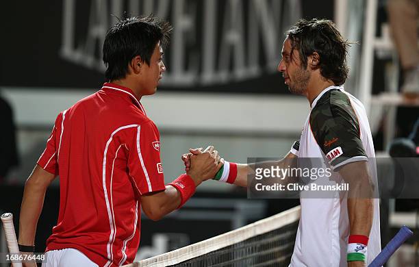 Kei Nishikori of Japan shakes hands at the net after his straight sets victory against Paolo Lorenzi of Italy in their first round match during day...
