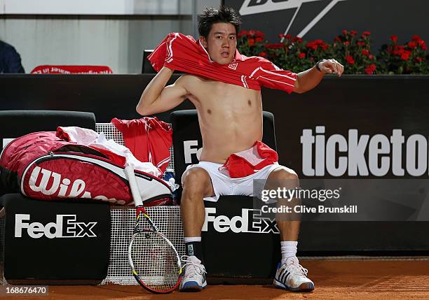 Kei Nishikori of Japan changes his shirt during a change of ends against Paolo Lorenzi of Italy in their first round match during day two of the...