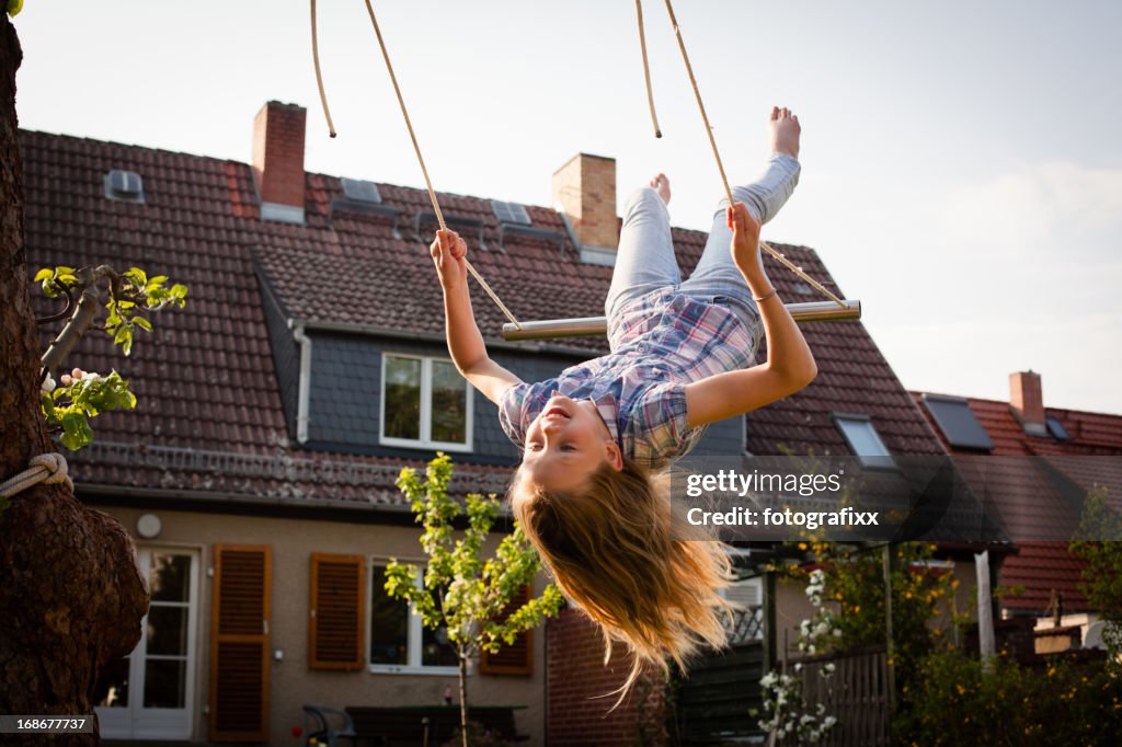 A young girl swinging in the backyard