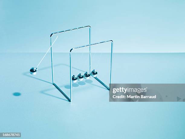 newton's cradle schwingen - kugelstoßpendel stock-fotos und bilder