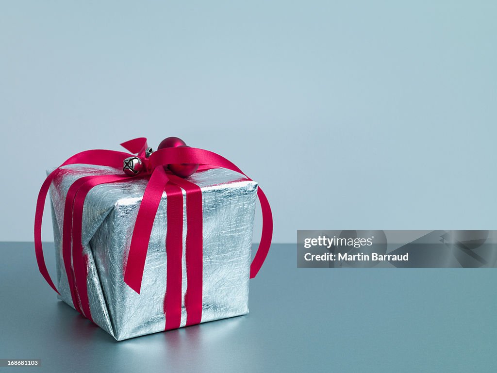 Christmas gift with red ribbon and silver wrapping