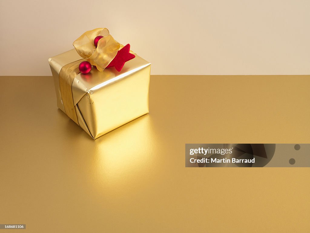 Christmas gift with gold ribbon and gold wrapping