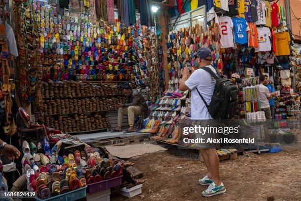 Tourist takes a photo of a babouche stall at the souk on September 17, 2023 in Marrakech, Morocco. A huge earthquake measuring 6.8 on the Richter...