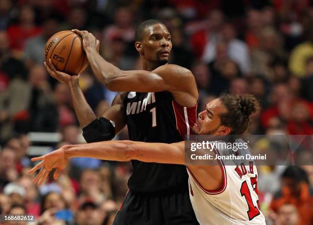 Chris Bosh of the Miami Heat looks to pass against Joakim Noah in Game Four of the Eastern Conference Semifinals during the 2013 NBA Playoffs at the...