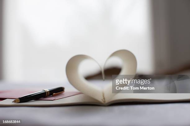 pen and pages of notebook forming heart-shape - love letter stock pictures, royalty-free photos & images