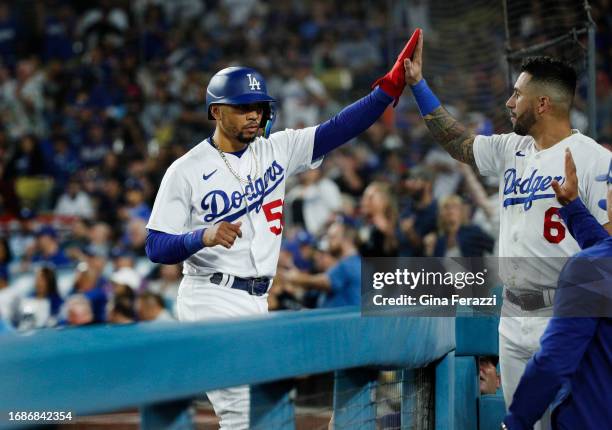 Los Angeles Dodgers Mookie Betts gets a high-five from Los Angeles Dodgers left fielder David Peralta after scoring against the San Francisco Giants...