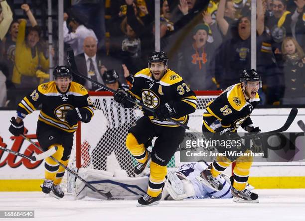 Patrice Bergeron, Tyler Seguin, and Brad Marchand of the Boston Bruins celebrate following Bergeron's game-winning overtime goal against the Toronto...