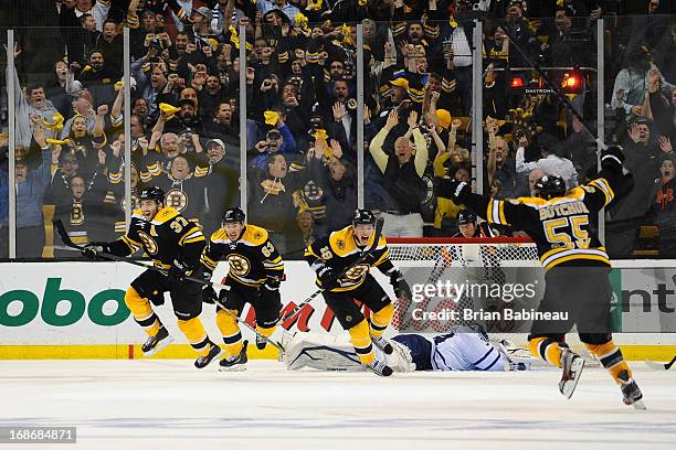 Patrice Bergeron, Brad Marchand, Tyler Seguin and Johnny Boychuk of the Boston Bruins react to winning in overtime against the Toronto Maple Leafs in...