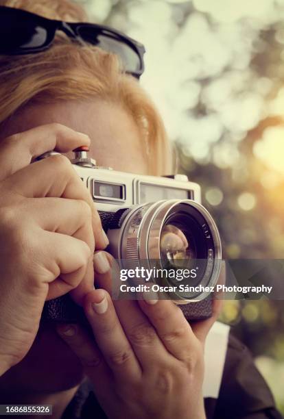 woman taking a shot with an 35mm analog camera - body camera stock pictures, royalty-free photos & images