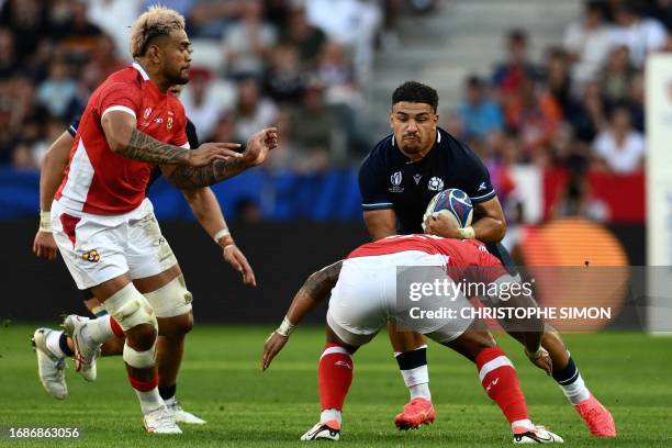 Scotland's inside centre Sione Tuipulotu is tackled by Tonga's inside centre Pita Ahki and Tonga's number eight Vaea Fifita during the France 2023...