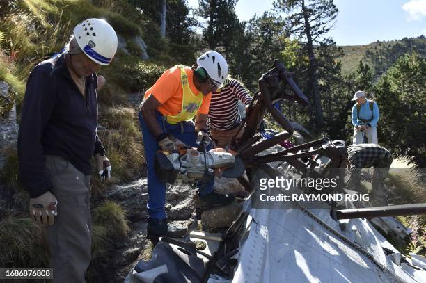 Volunteers take part in a clean-up operation for remaining debris of the DC3 plane that crashed on October 7 causing the death of 34, in the Canigou...