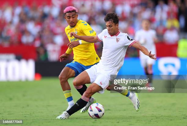 Oliver Torres of Sevilla runs with the ball whilst under pressure from Julian Araujo of Las Palmas during the LaLiga EA Sports match between Sevilla...