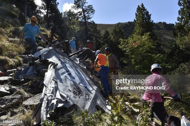 Volunteers take part in a clean-up operation for remaining debris of the DC3 plane that crashed on October 7 causing the death of 34, in the Canigou...