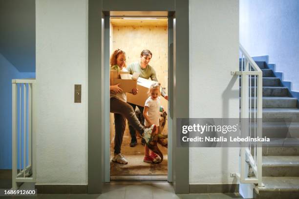 family with boxes in elevator near stairs in multi-story building - hiss bildbanksfoton och bilder