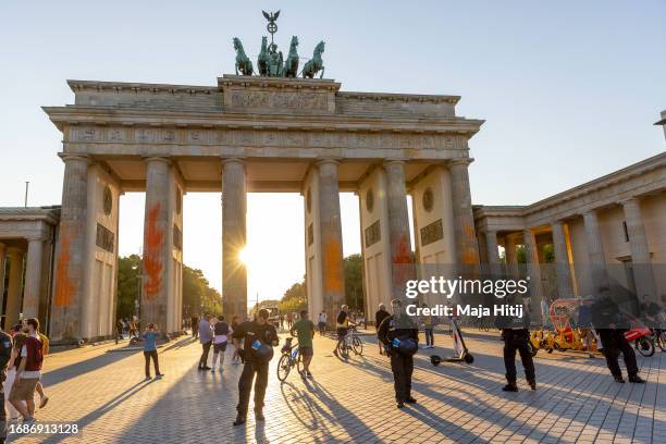 Brandenburg Gate stands spray-painted as tourists and visitors walk past on September 17, 2023 in Berlin, Germany. Supporters of the climate action...