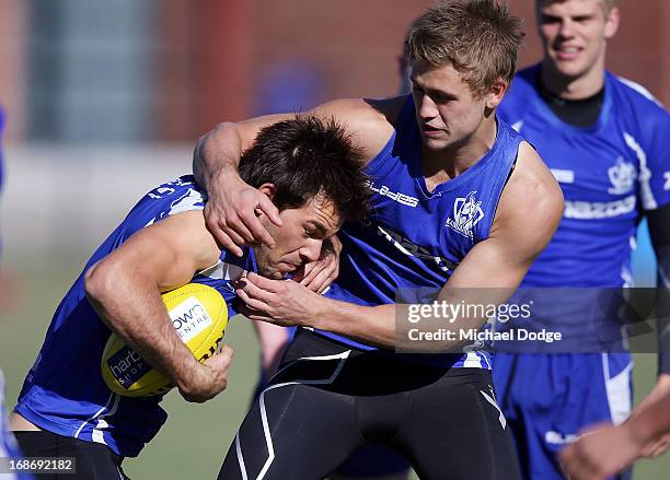 Levi Greenwood gets tackled by Kieran Harper during a North Melbourne Kangaroos AFL training session at Aegis Park on May 14, 2013 in Melbourne,...