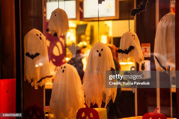 bright, spooky city store decorated for halloween. street decoration. scary ghosts window, bat, web - halloween photos et images de collection