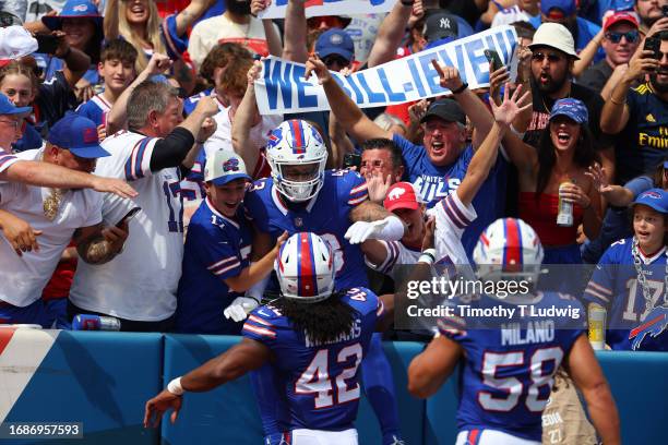 Buffalo Bills fans celebrate with Terrel Bernard of the Buffalo Bills while Dorian Williams of the Buffalo Bills and Matt Milano of the Buffalo Bills...