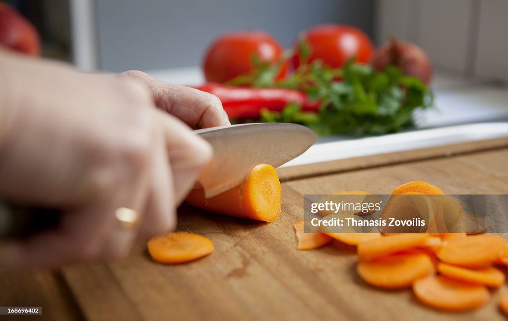 Woman cutting carrot