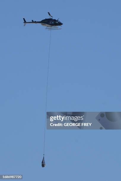 Helicopter carries NASA's Osiris-Rex asteroid sample return craft from the Utah desert, where it landed, to a clean room at Dugway, Utah, on...