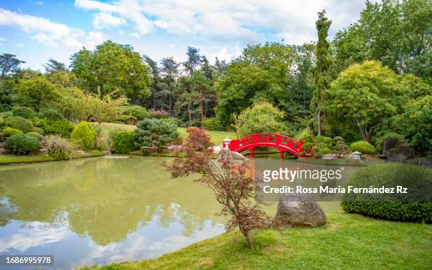pond with a red bridge in the japanese garden of the city built in 1981. it is located inside the compans-caffarelli park - haute garonne imagens e fotografias de stock