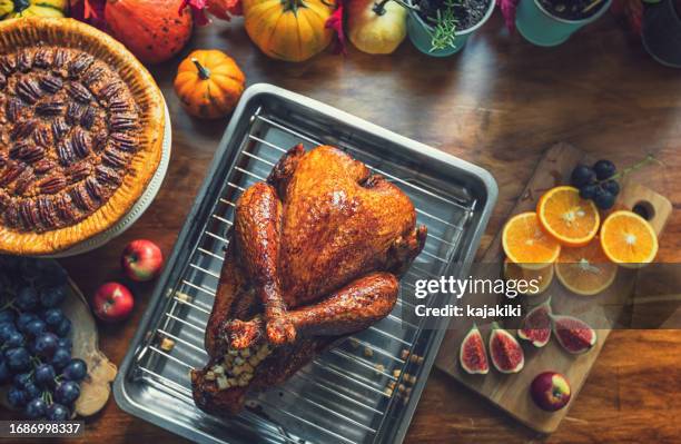 preparing stuffed turkey with side dishes for thanksgiving celebration - fylld kalkon bildbanksfoton och bilder