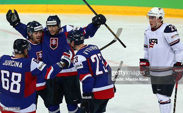 Justin Faulk of USA looks dejected while Tomas Zaborsky and Roman Kukumberg of Slovakia celebrate their 3rd during the IIHF World Championship group...