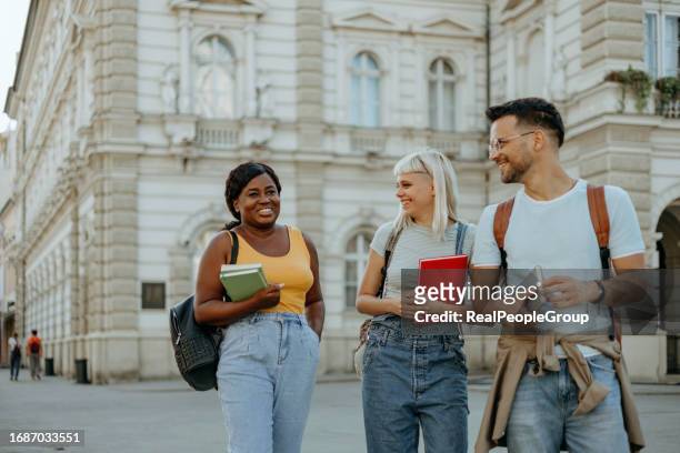 eine gruppe von studenten, die spazieren gehen und sich unterhalten - university students real studying stock-fotos und bilder