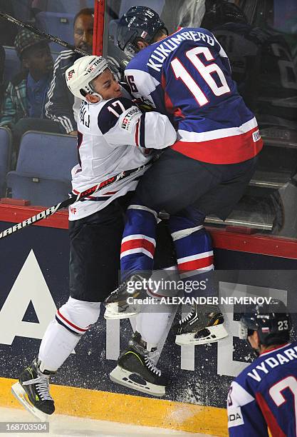 Forward Aaron Palushaj vies for the puck with Slovakia's forward Roman Kukumberg during the preliminary round match Slovakia vs USA at the 2013 IIHF...