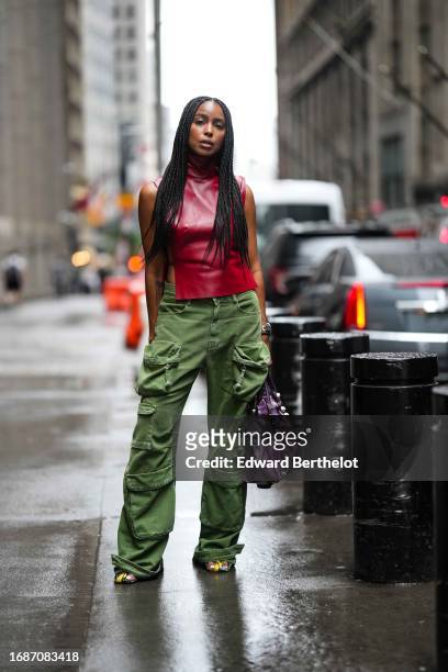 Guest wears a red turtleneck leather tank top, green cargo pants, a purple Balenciaga bag, outside Alice & Olivia, during New York Fashion Week, on...