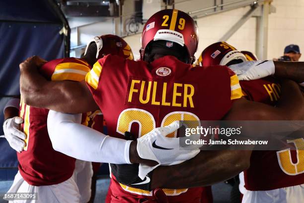 Kendall Fuller of the Washington Commanders prays with teammates prior to a game against the Denver Broncos at Empower Field At Mile High on...