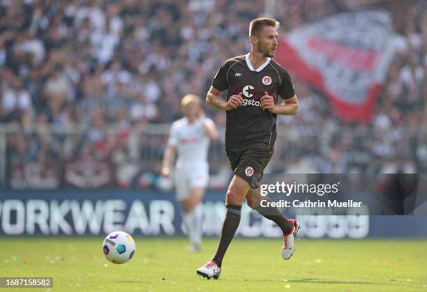 Karol Mets of FC St. Pauli runs with the ball during the Second Bundesliga match between FC St. Pauli and Holstein Kiel at Millerntor Stadium on...