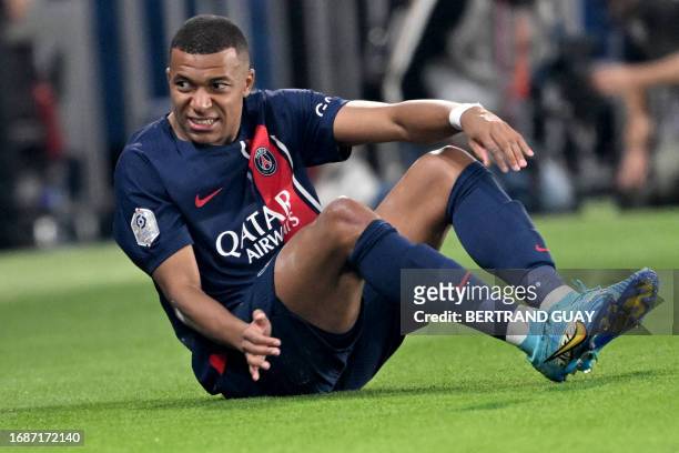 Paris Saint-Germain's French forward Kylian Mbappe grimaces after a shock during the French L1 football match between Paris Saint-Germain and...