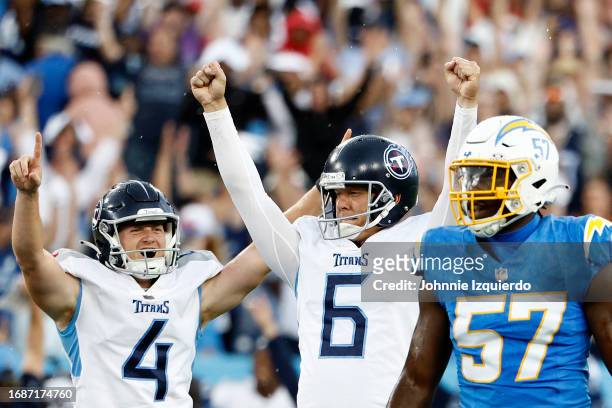 Ryan Stonehouse of the Tennessee Titans and Nick Folk of the Tennessee Titans celebrate Folk's game winning field goal in overtime as Amen...
