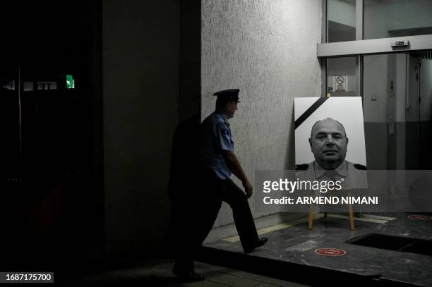 Kosovo police officer walks past a portrait of his colleague Afrim Bunjaku, who was killed by armed gunmen in the village of Banjska near the border...