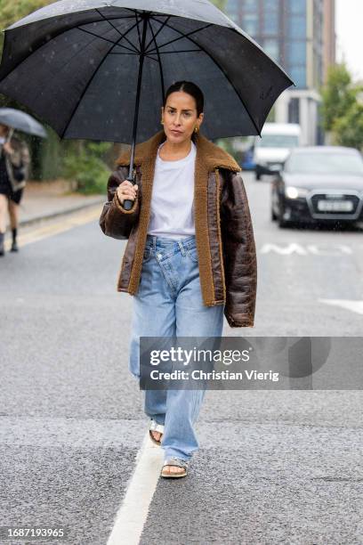 Idalia Salsamendi is seen wearing brown shearling jacket, denim jeans, white shirt outside Holzweiler during London Fashion Week September 2023 on...