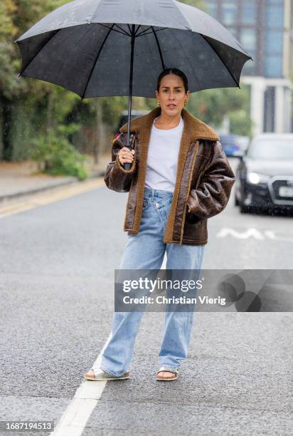 Idalia Salsamendi is seen wearing brown shearling jacket, denim jeans, white shirt outside Holzweiler during London Fashion Week September 2023 on...