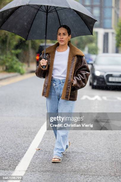 Idalia Salsamendi is seen wearing brown shearling jacket, denim jeans, white shirt outside Holzweiler during London Fashion Week September 2023 on...